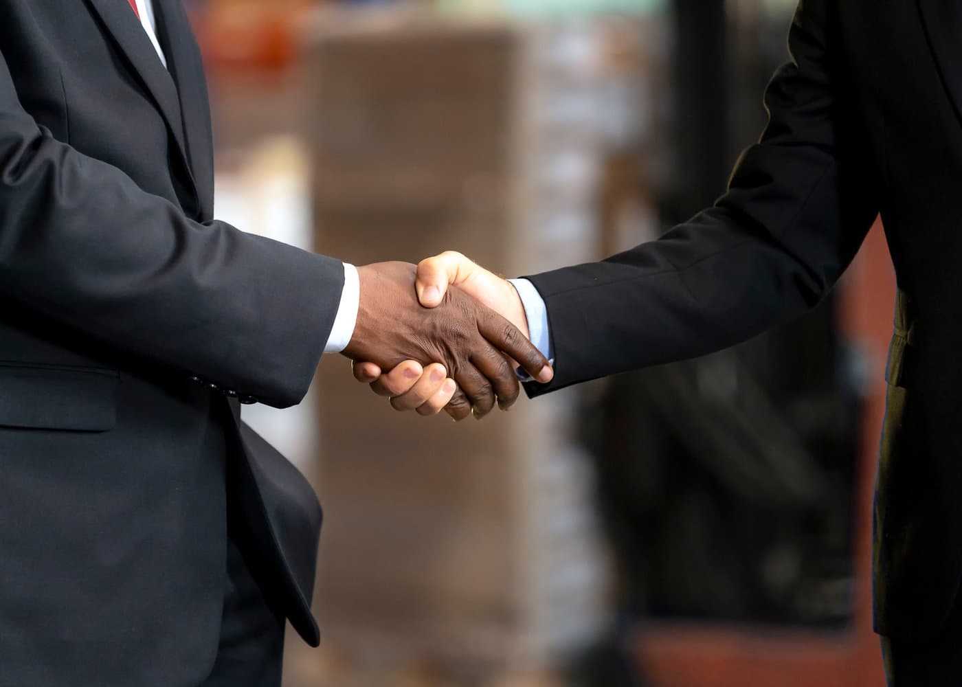 Business partners shaking hands across a meeting table